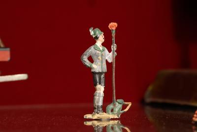 Figurilla de plomo: hombre con báculo.