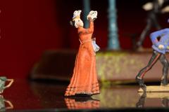 Figurilla de plomo: persona vestido rojo.