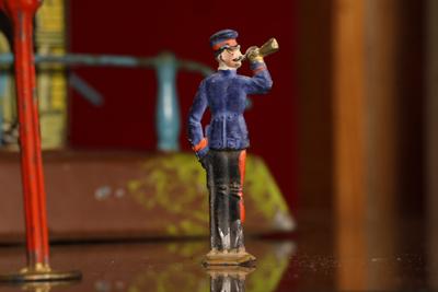 Figurilla de plomo: guardia con instrumento de viento.