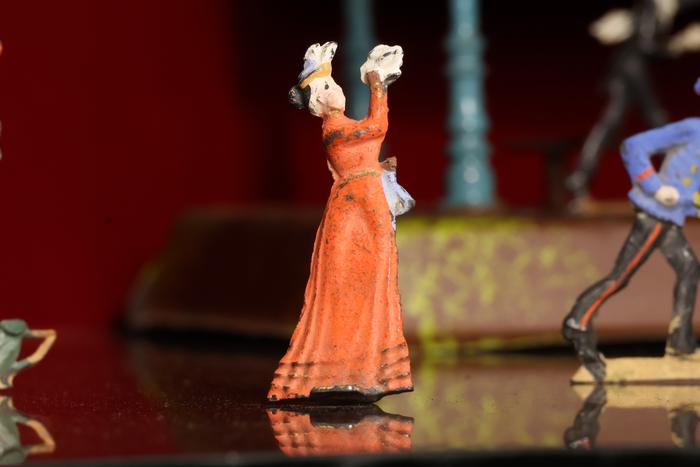 Figurilla de plomo: persona vestido rojo.